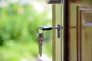 close up of key inside door with summer greenery in the background